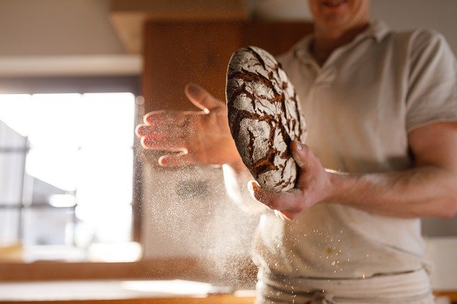boulanger avec un pain dans les mains